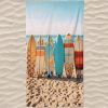 Toalla de playa de microfibra con tablas de surf en la playa.