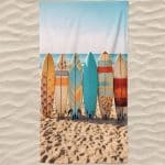 Toalla de playa de microfibra con tablas de surf en la playa.