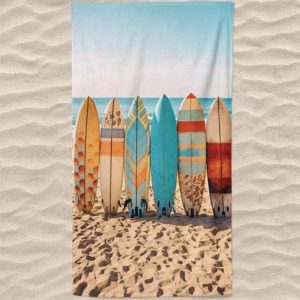 Toalla de playa de microfibra con tablas de surf en la playa.